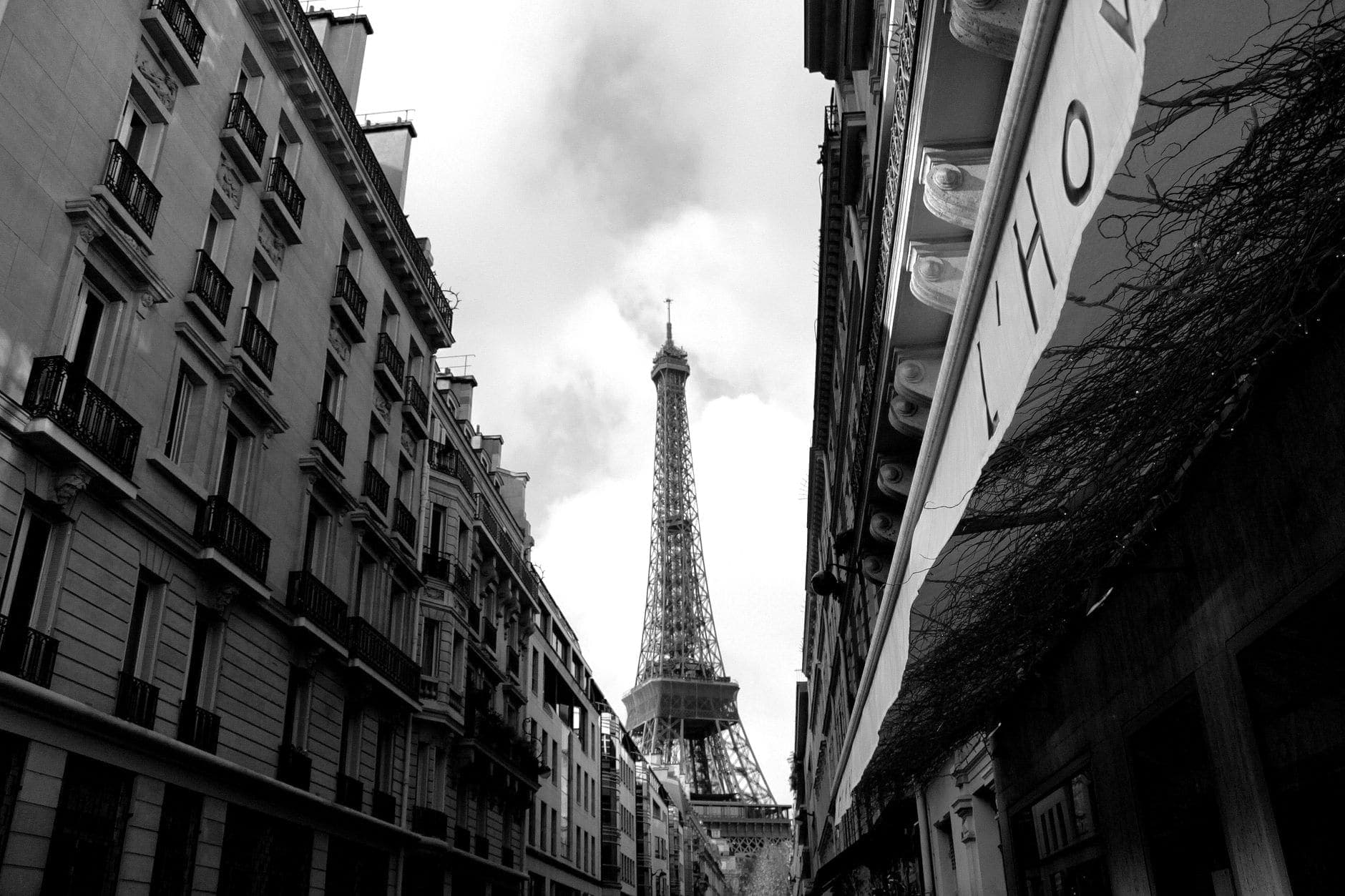 Black and white view of Eiffel Tower framed by Parisian streets, showcasing classic architecture.
